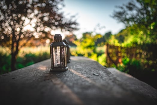 Oil, candle lantern on a wooden table on a camping site. photo