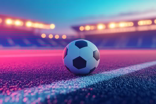 A soccer ball rests on the field at dusk near bright stadium lights before a match begins photo