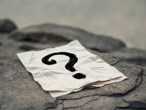 Question mark on paper on rock photo