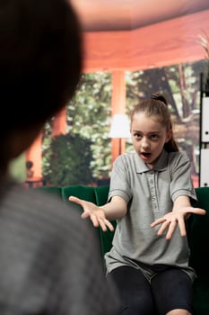 Troubled teen displays aggression and anger during therapy session, rebellious adolescent throwing a tantrum. Expert focuses on resolving issues like anger management issues and negative behavior. photo