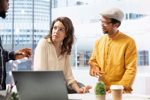 Real estate agent advises business people on property investment opportunity, using blueprints to plan the layout of a modern high class office space. Clients agreeing on rental contract. photo