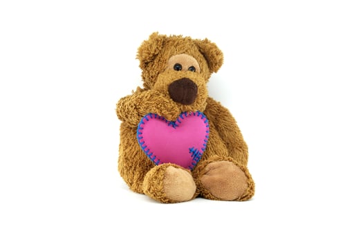 Cute Teddy Bear Holding a Heart-Shaped Pillow photo