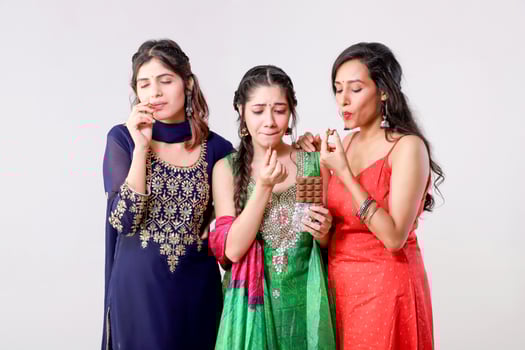 Female Best Friends in Salwar Kameez Suit Enjoying Eating Chocolate photo