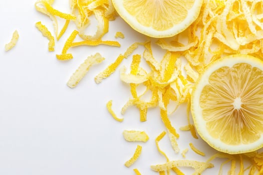 Vibrant yellow lemon zest is artfully arranged around halved lemons, highlighting their juicy flesh and aromatic zest. This fresh preparation adds a bright touch to culinary creations. photo