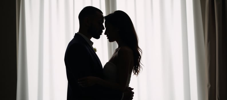 African American couple embracing silhouetted against empty backdrop with heart symbol and word love photo