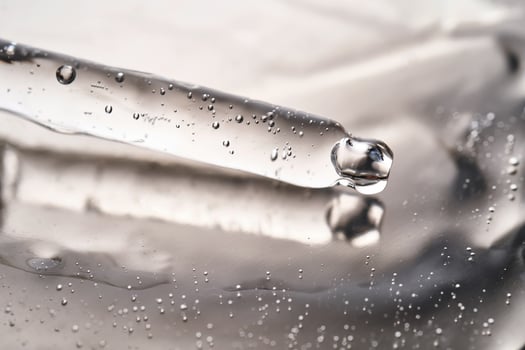 Dropper pipette with delicious serum with bubbles on the gel texture. photo