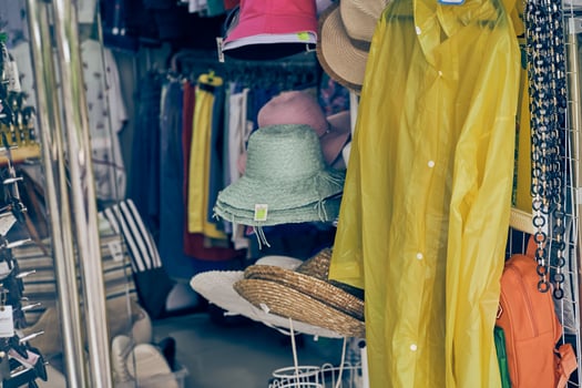 A room with summer season clothes without people. In the foreground is a yellow raincoat. The concept of outdoor shopping photo