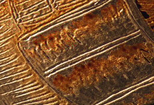 A close up of a metal object with some lines photo