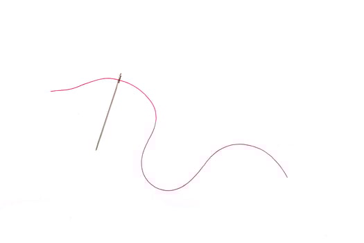 needle and thread of red color on a white background photo