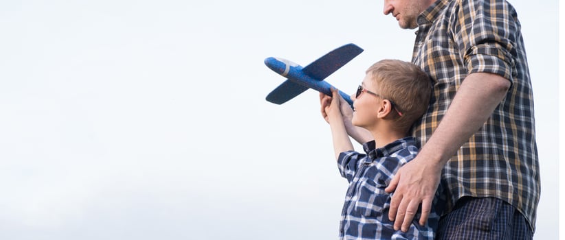 Father and son having fun in the field playing with an airplane photo
