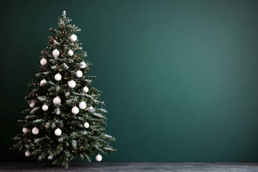 Beautifully decorated Christmas tree with silver ornaments against a dark green background photo