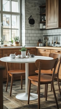 Cozy kitchen dining setup with wooden cabinets and round table near window in a sunlit room photo