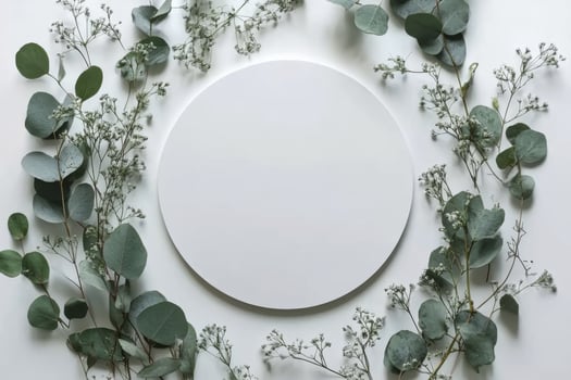 A simple wooden circle surrounded by delicate greenery on a white background photo