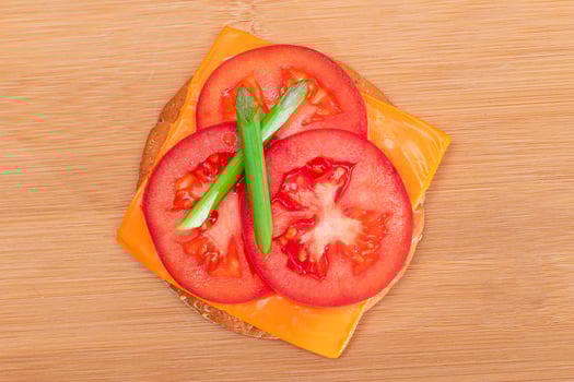 Crispy Cracker Sandwich with Tomato, Cheese and Green Onions on Cutting Board. Easy Breakfast. Diet Food. Quick and Healthy Sandwiches. Crispbread with Tasty Filling. Healthy Dietary Snack photo