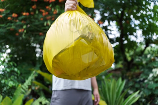 Man Volunteer charity holding garbage yellow bag and plastic bottle garbage for recycling cleaning photo