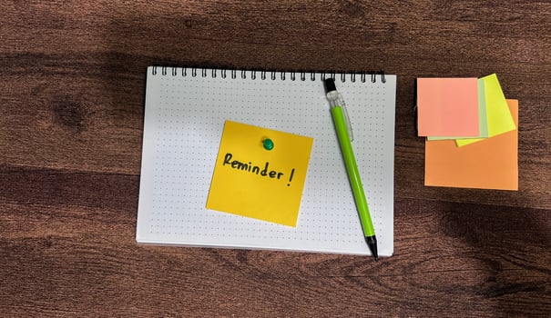 Concept of Reminder write on sticky notes isolated on Wooden Table. photo