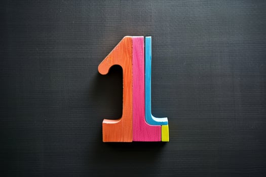 A wooden number 1 is cut into pieces and placed on a black background photo