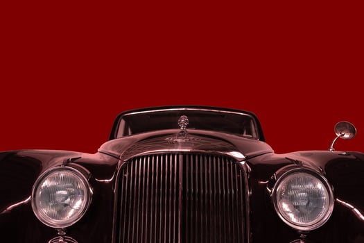 Vintage, black, shiny car on a red background. photo