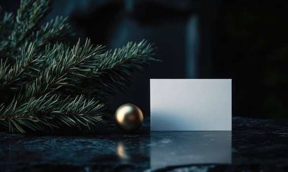 A white card is on a table next to a gold ball photo