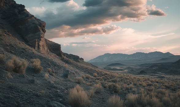 A rocky hillside with a cloudy sky in the background photo