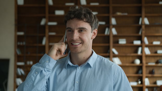 Glad positive successful Caucasian man male guy businessman talking speak online mobile phone call consulting client cellphone discussion solving business question friendly conversation indoors office photo