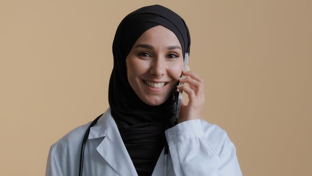 Muslim islamic doctor young intern arab woman surgeon intern in hijab wear medical coat talk by cellphone with patient female advisor consult distant virtual mobile communication health care concept photo