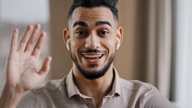 Happy young coach arab man blogger wears wireless earphones say hello at camera subscribers record lifestyle blog use wi-fi internet make call provide teach distance tutorial educational course photo