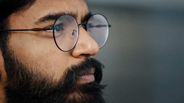 Close up profile face view portrait bearded thoughtful arabian boss entrepreneur business man in glasses indoor dreaming looking away lost in thoughts search ideas self-isolation due covid pandemic photo