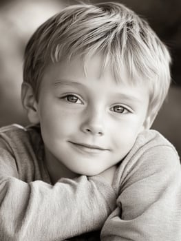A young boy with blonde hair and a smile photo