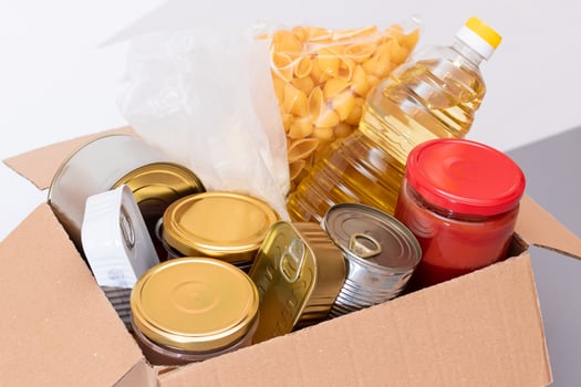 Donation Box of Free Food. Carton Box with Canned Food, Cereals and Grocery. Meal Reserves. Emergency Food Storage in Case of Crisis. Free Social Help, Blessings and Care. Strategic Food Supplies photo