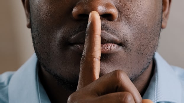 Mysterious unknown male face part african american adult man put finger to lips ask be quiet make gesture silence show secrecy sign keep secret confident information silent forbid tell close up view photo