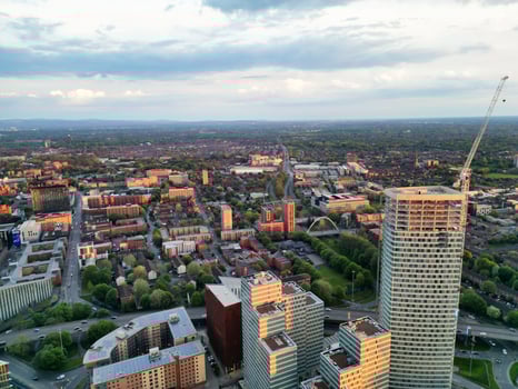 Aerial View of Greater Manchester City Centre and Tall Buildings During Golden Hour of Sunset. England UK. High Angle Footage Was Captured with Drone's Camera During Windy day of May 5th, 2024 photo