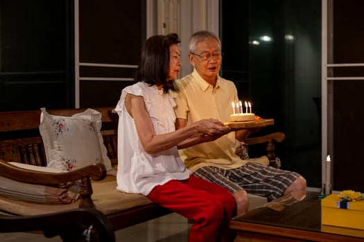 Senior asian couple is celebrating birthday together at home for love, relationship, bonding, longevity and marriage concept photo