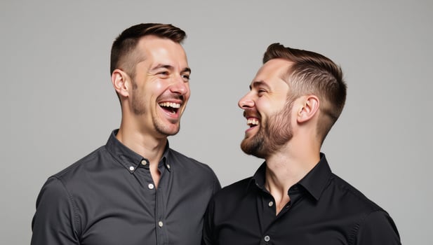 An enthusiastic gay couple sharing a joyful moment against a gray background photo