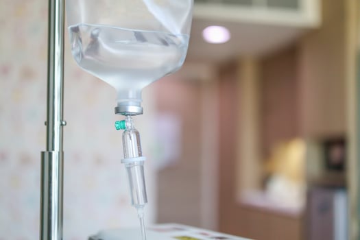 Close up medical intravenous IV drip in hospital background photo