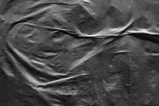 Black crumpled and creased paper poster grunge texture background photo