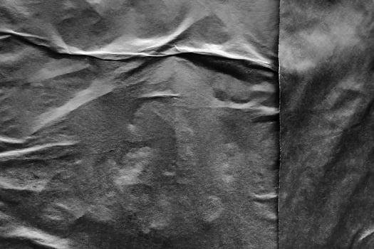 Black crumpled and creased paper poster grunge texture background photo