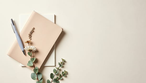 Blank notebook, pen and flowers on beige background photo