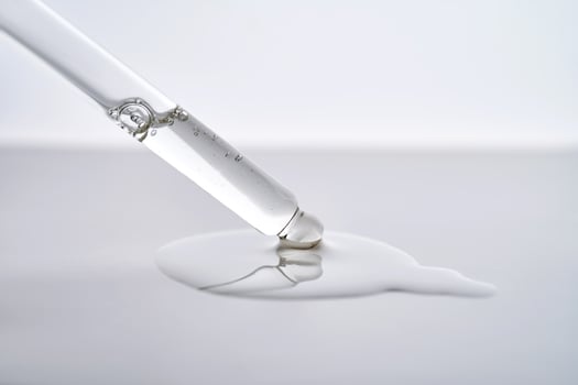 Dropper pipette with delicious serum with drop close-up. photo