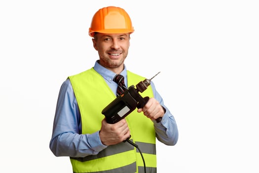 Repairman Worker Holding Electric Drill Posing Smiling To Camera Over White Studio Background. Building Tools Concept photo