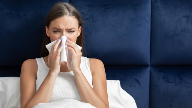 Sick Lady Blowing Nose Sneezing In Paper Tissue Sitting In Bed At Home During Coronavirus Outbreak. photo