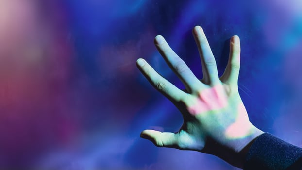Mystical backdrop with outstretched hand illuminated by eerie lights photo