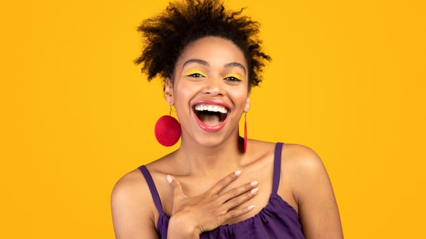 Sincere Human Emotions. Portrait of cute black girl laughing out loud over yellow studio wall, free space photo