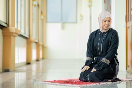 The image of an Asian Muslim woman in the Islamic religion in hijab in cream color. She was praying in a beautiful mosque out of respect for God. photo