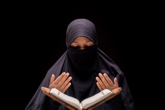 Portrait Asian Muslim woman standing and reading the Quran and appreciates and faith photo