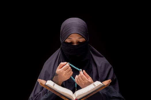 Portrait Asian Muslim woman standing and reading the Quran and appreciates and faith photo
