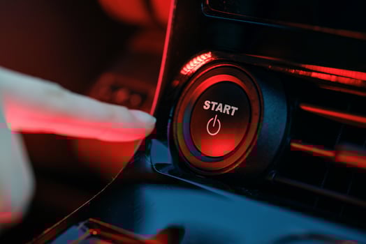 hand pressing start button on car panel, action activation concept photo