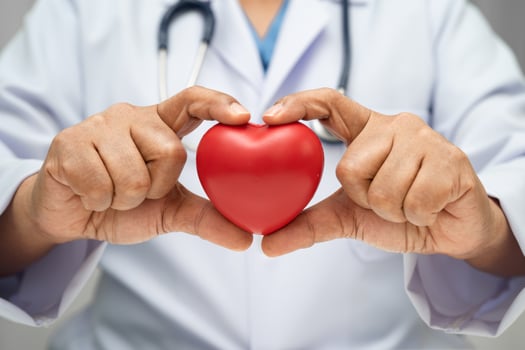 Doctor holding a red heart in hospita, healthy strong medical. photo
