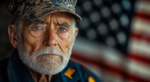 A man with a military hat and beard is looking at the camera. The image has a patriotic mood photo
