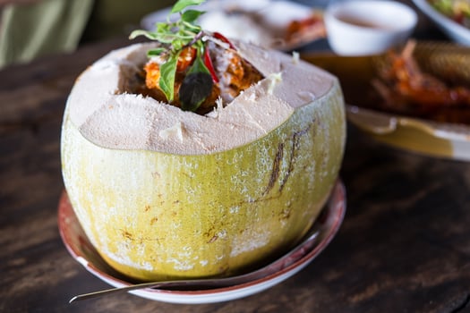 Thai food called Ho Mok Talay in white young coconut shell. Creative food styling presenting original authentic photo